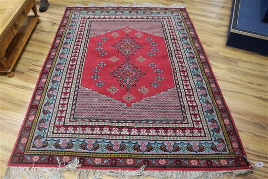A red ground rug, 240cm x 172cm